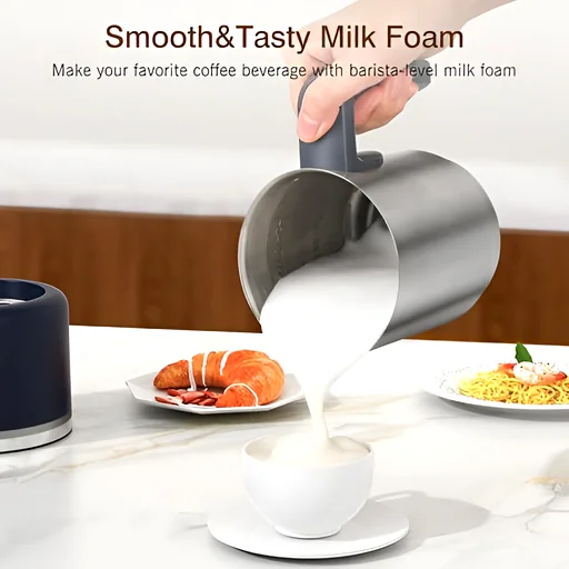 Stainless steel frother pitcher pouring creamy milk foam into a white cup, showing smooth texture and controlled pour